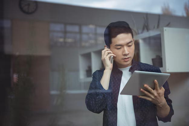 business-executive-talking-mobile-phone-while-using-digital-tablet_107420-63915